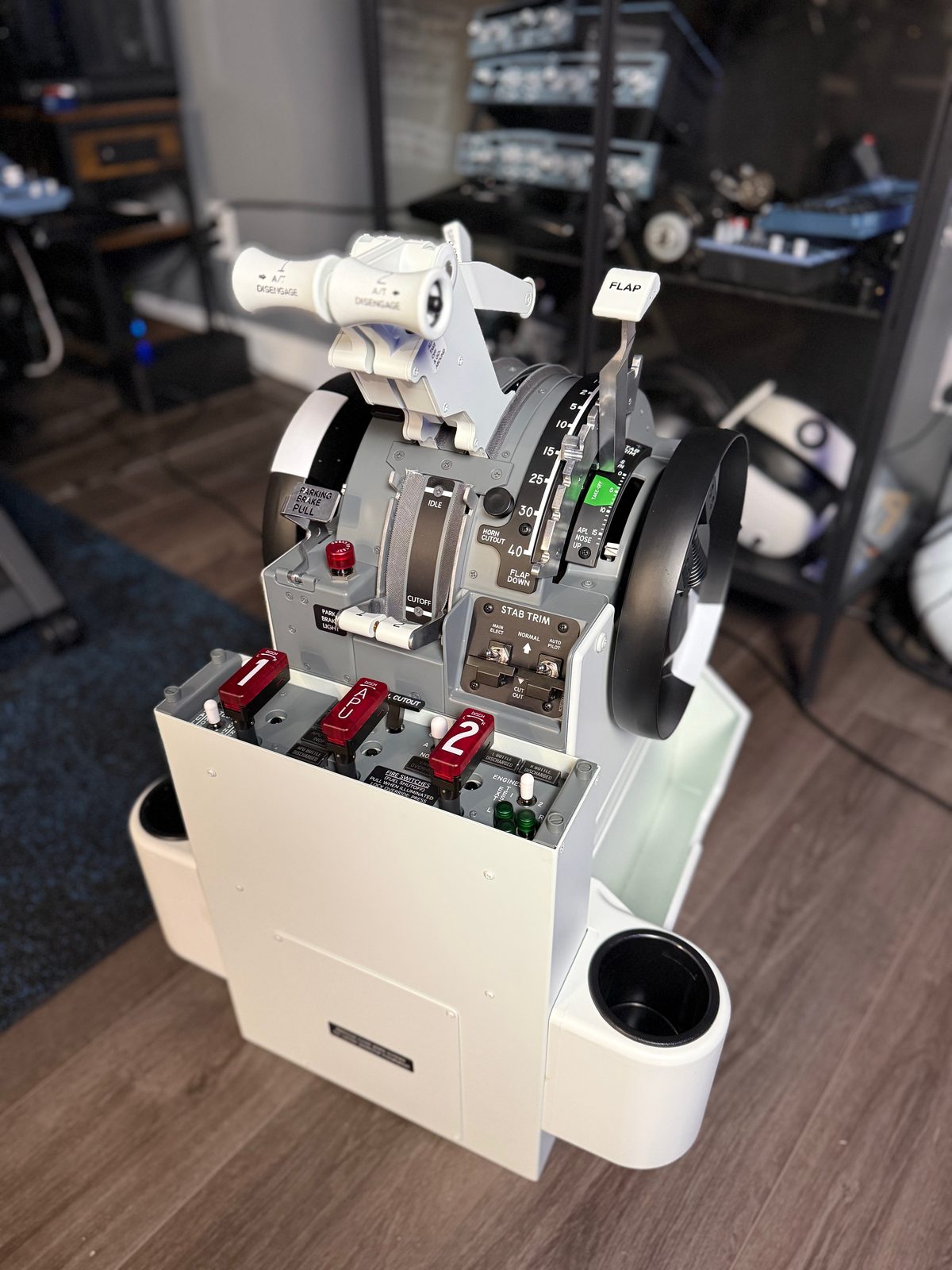 Three-quarter view of the Cockpit Simulator throttle assembly, white pedestal and fire handles.